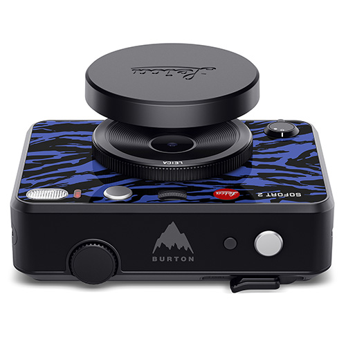 Leica Sofort 2 Burton Sofortbildkamera - Ansicht von vorne oben mit aufgesetztem Auslöseknopf in Sonderdesign